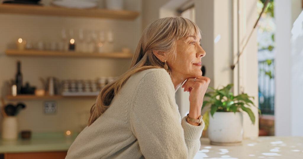 Window, smile and elderly woman with thinking at home for retirement
